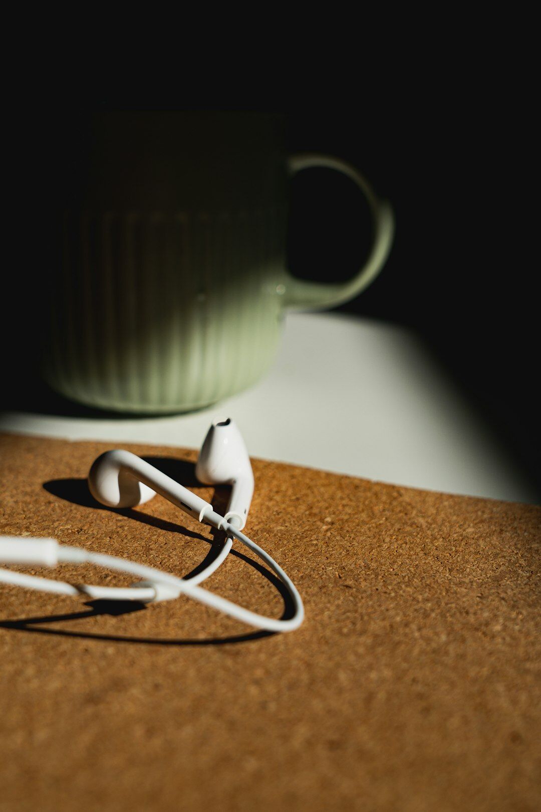 Notebook and coffee cup next to a podcast microphone on a desk