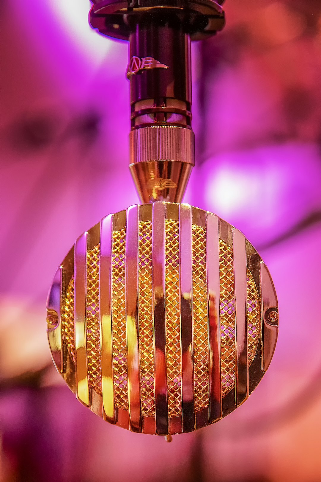 Close-up of a studio microphone with soft warm lighting